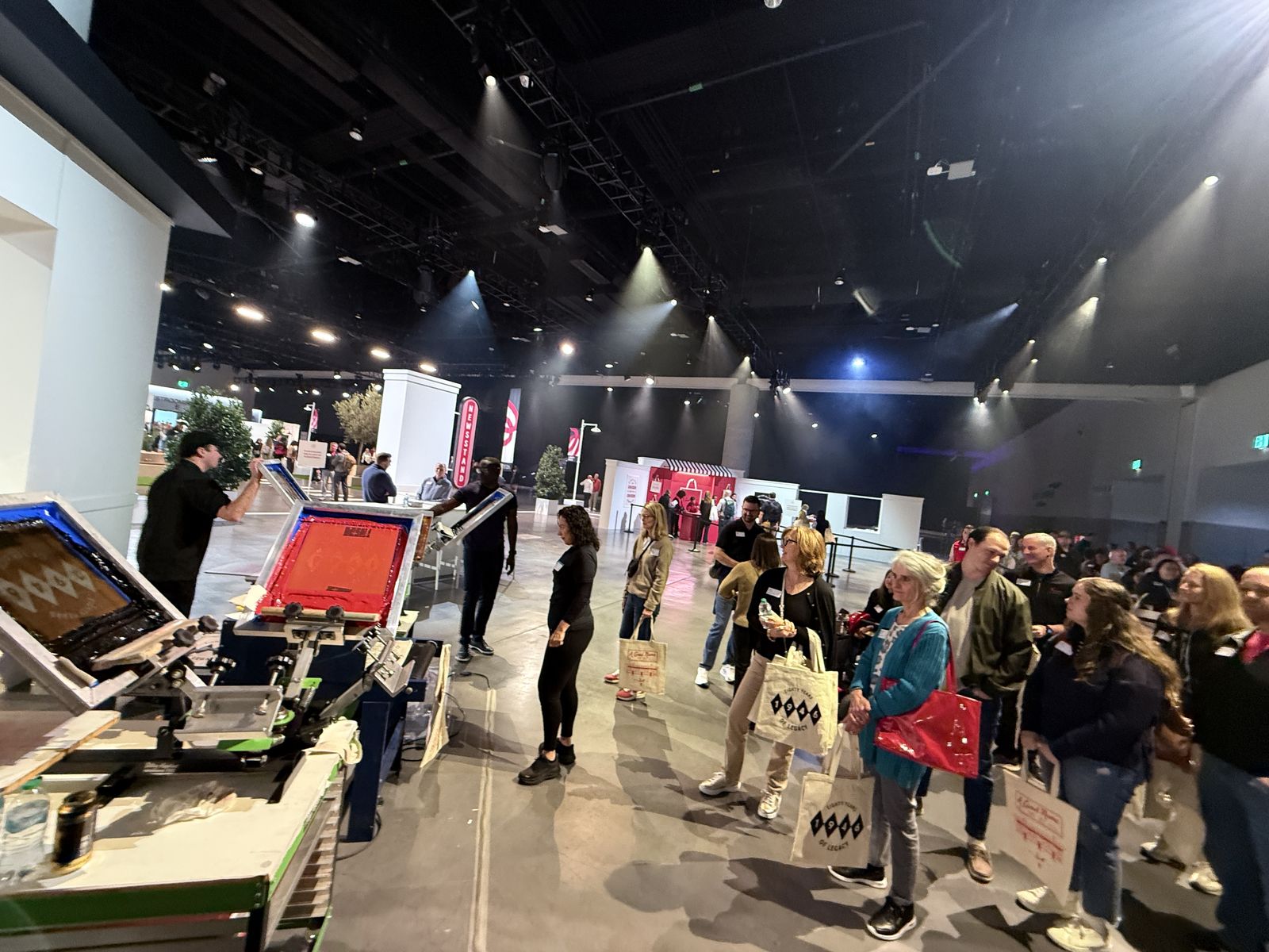 Merch Troop crew running a live station on a gala floor while guests line up with canvas totes